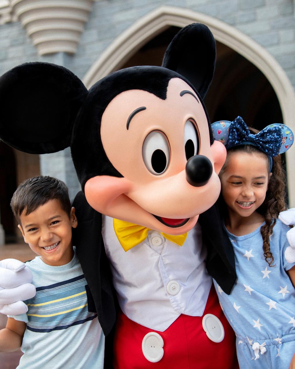 Mickey Mouse con niños frente al castillo de Cinderella